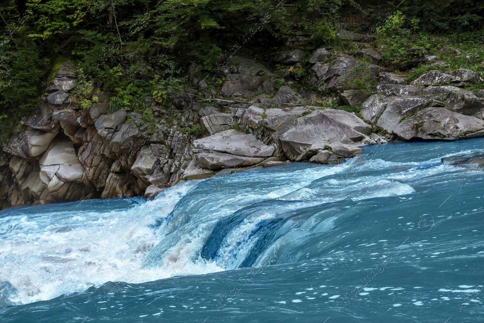 Photo of Mountain river flowing along rocky banks in wilderness