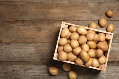 Raw fresh organic potatoes on wooden background, top view. Space for text