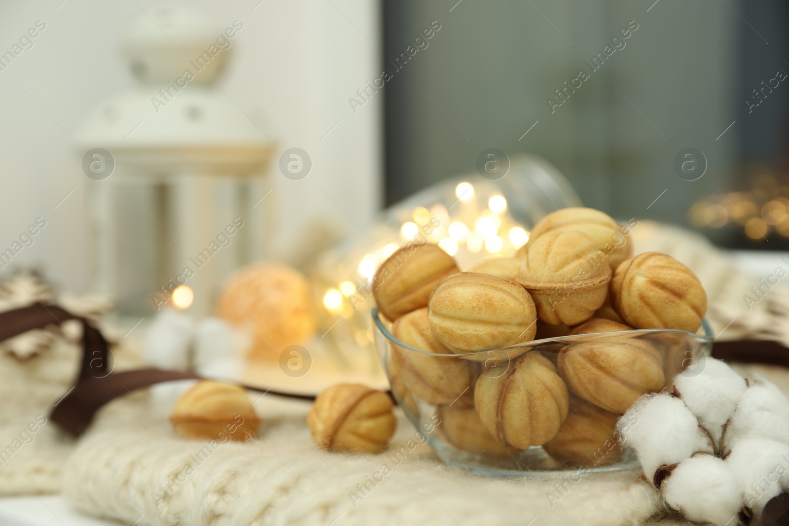 Photo of Delicious nut shaped cookies with boiled condensed milk and Christmas decor on knitted fabric. Space for text