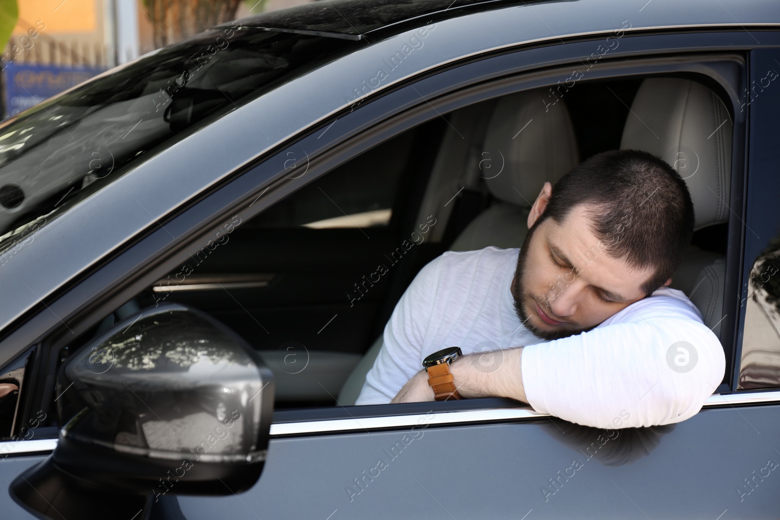 Photo of Tired man sleeping in his modern car