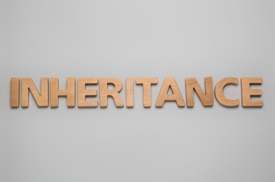 Photo of Word Inheritance made with wooden letters on light background, flat lay