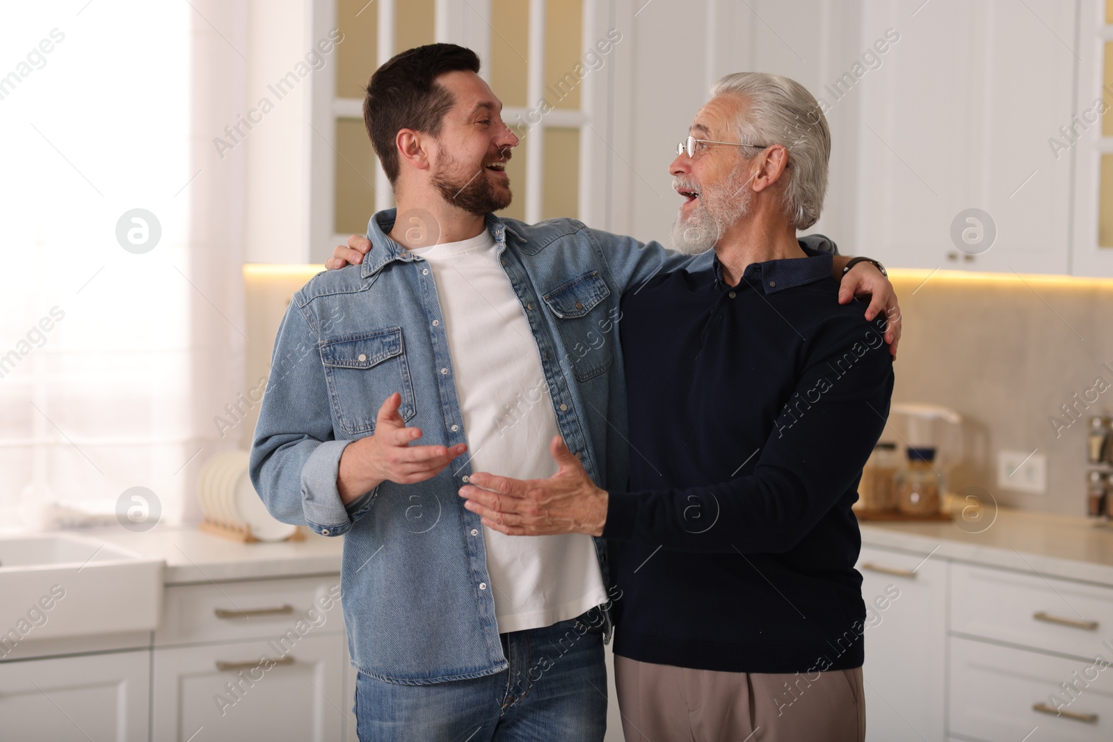 Photo of Happy son and his dad talking at home