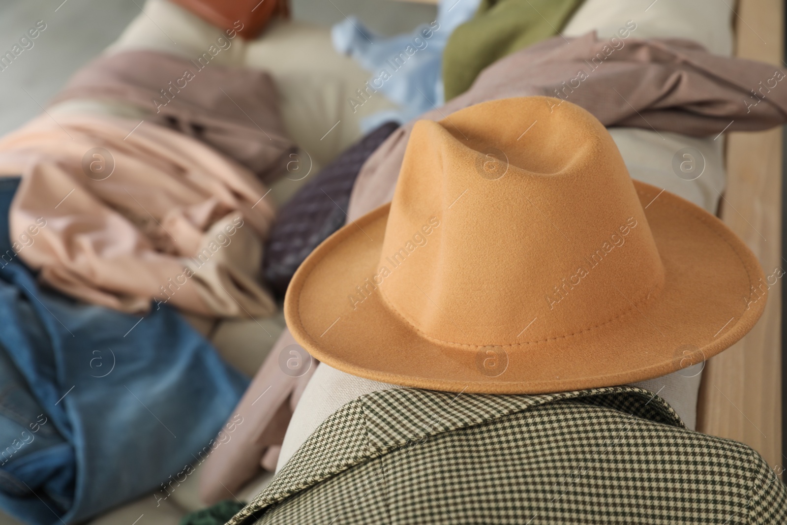 Photo of Hat and clothes on sofa indoors, space for text
