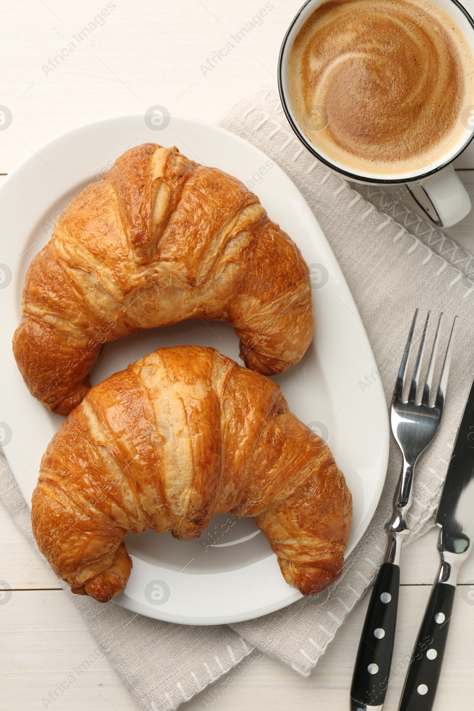 Photo of Delicious fresh croissants served with coffee on white table, flat lay