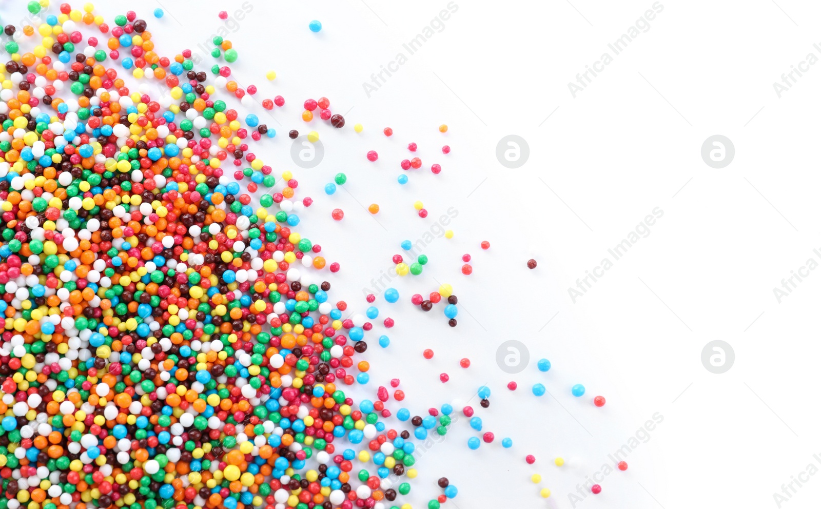 Photo of Colorful sprinkles on white background, top view. Confectionery decor