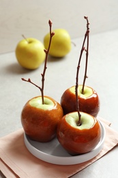 Photo of Plate with delicious green caramel apples on table