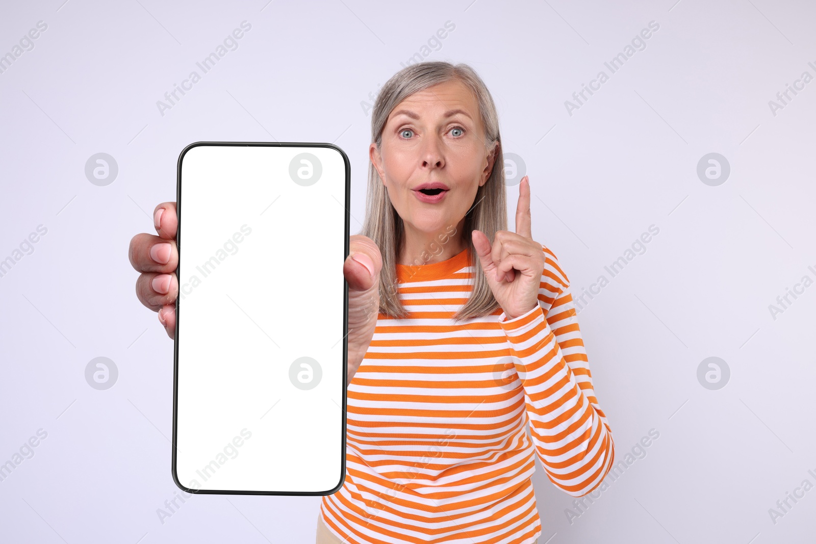 Image of Mature woman showing mobile phone with blank screen on white background. Mockup for design