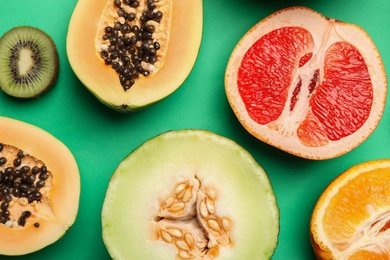 Flat lay composition with tasty melon and fresh tropical fruits on green background