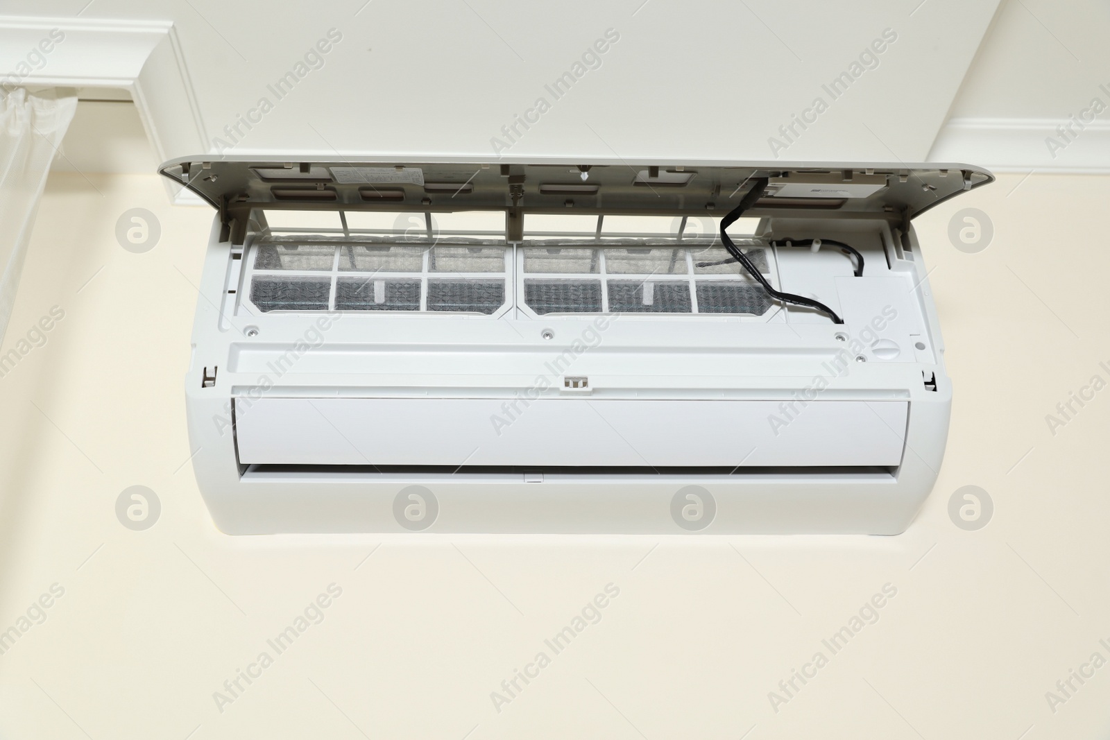 Photo of Modern air conditioner on white wall indoors