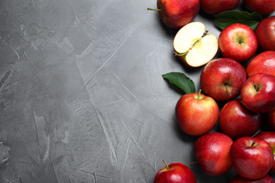 Ripe juicy red apples on grey table, top view. Space for text