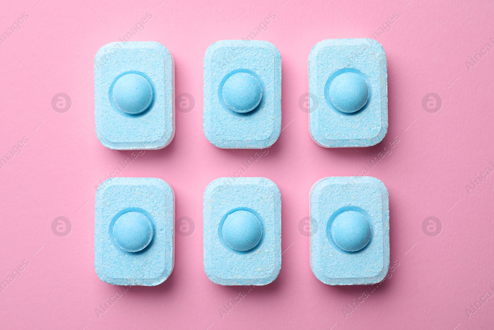 Photo of Water softener tablets on pink background, flat lay