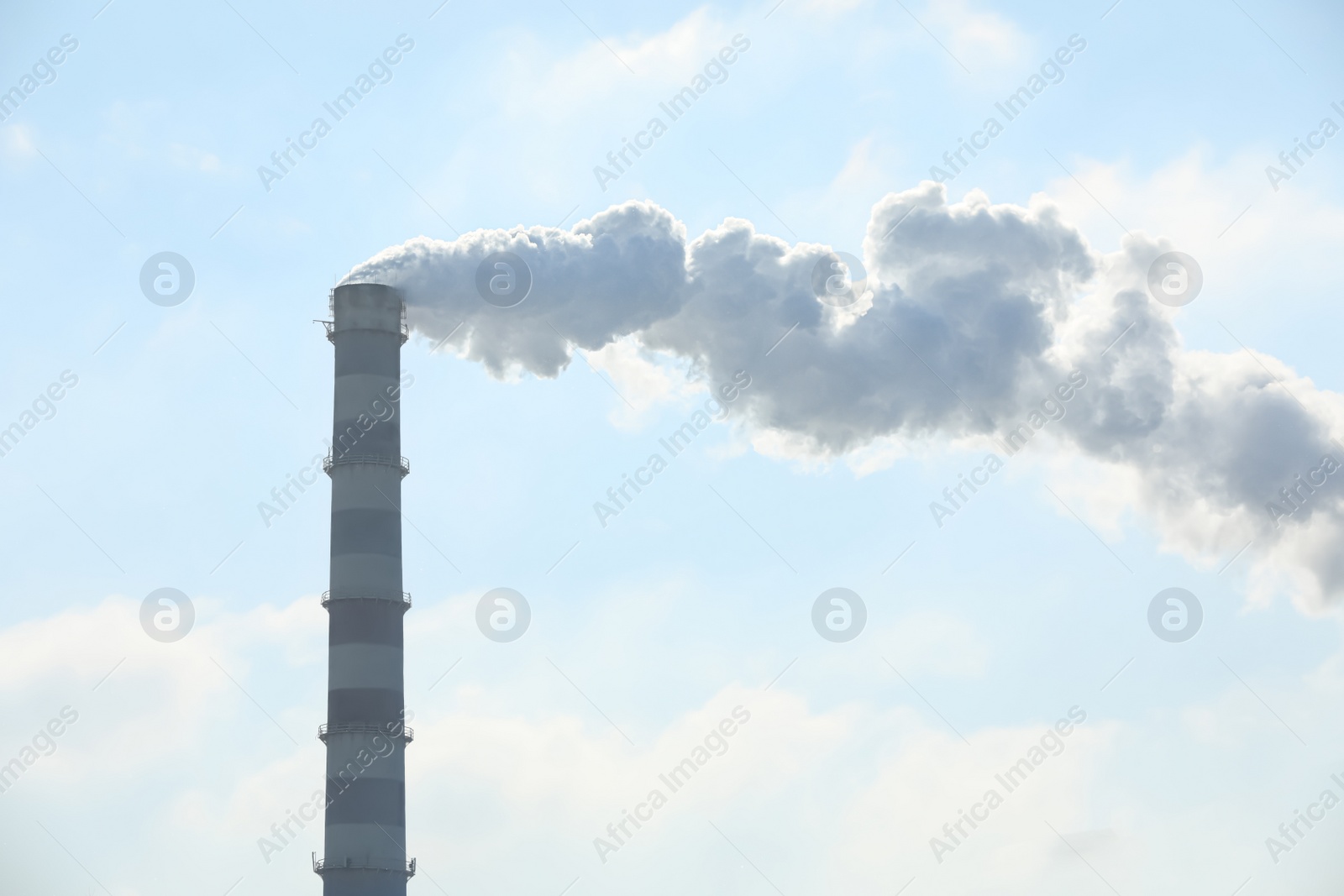 Photo of Polluting air with smoke from industrial chimney outdoors. CO2 emissions