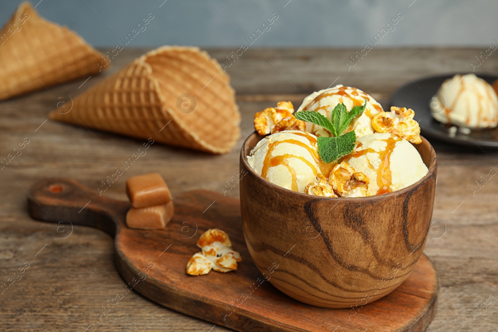 Photo of Delicious ice cream with caramel popcorn and sauce served on table. Space for text