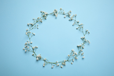 Photo of Frame made of beautiful gypsophila on light blue background, flat lay with space for text. Floral composition