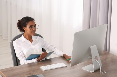 African American intern working with computer at table in office