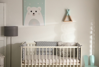 Photo of Cute baby room interior with crib and decor elements