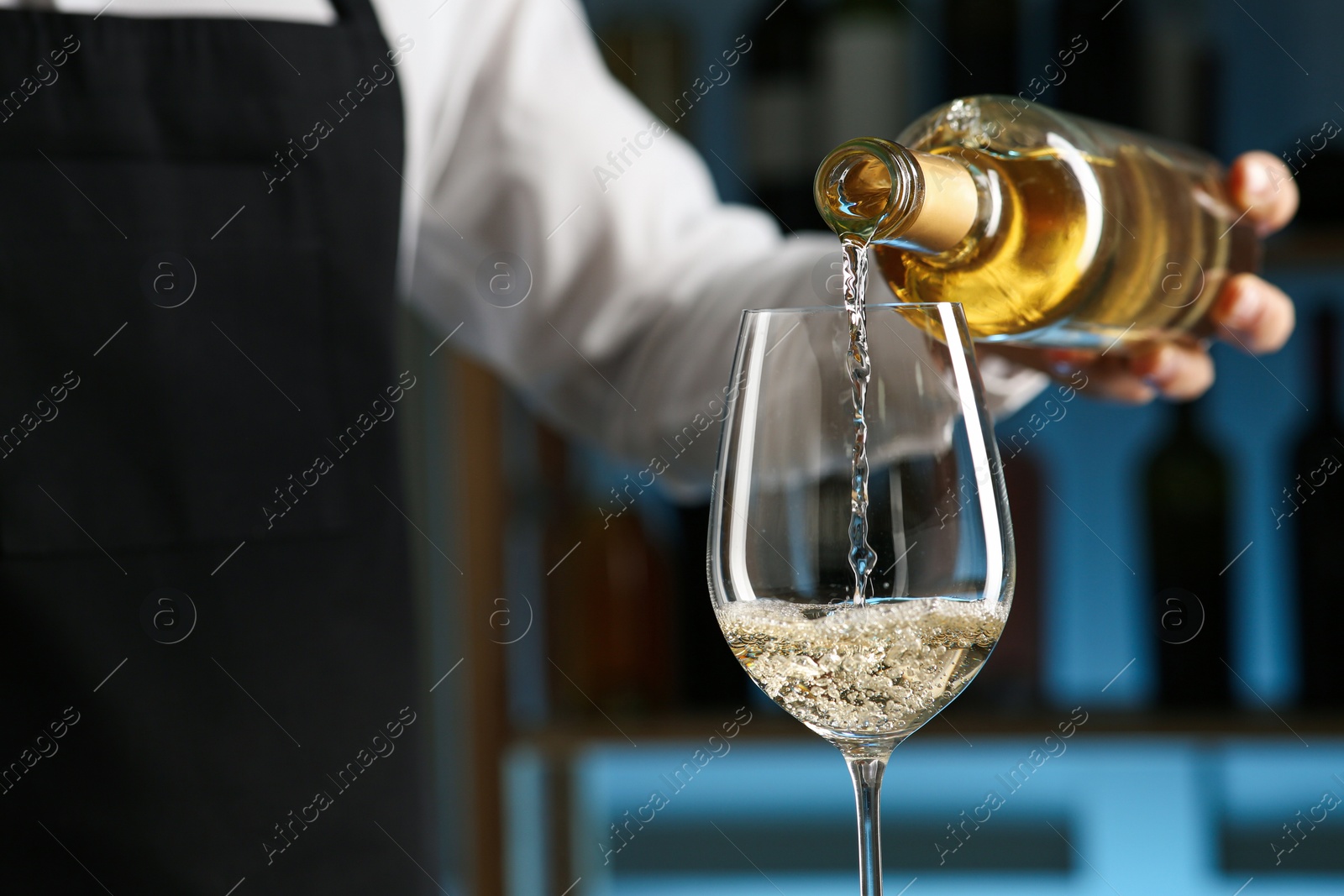 Photo of Bartender pouring wine into glass in restaurant, closeup