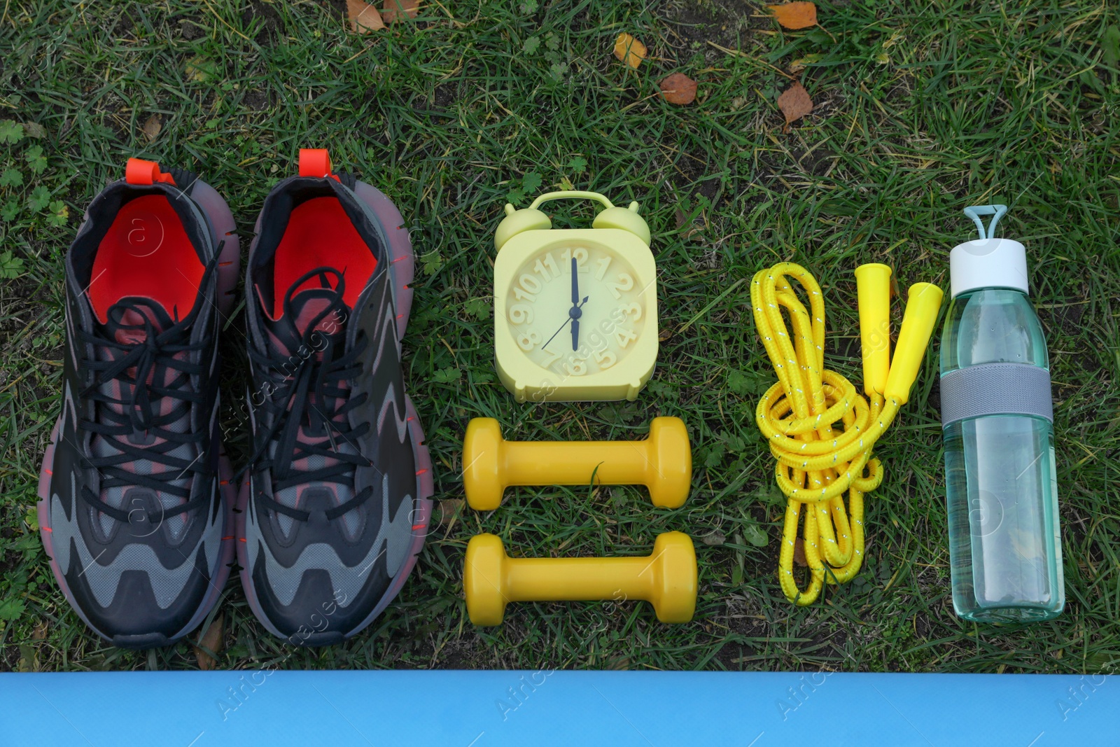 Photo of Set for morning exercise on green grass, flat lay