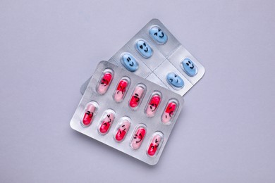 Photo of Different antidepressants with emoticons on grey background, flat lay