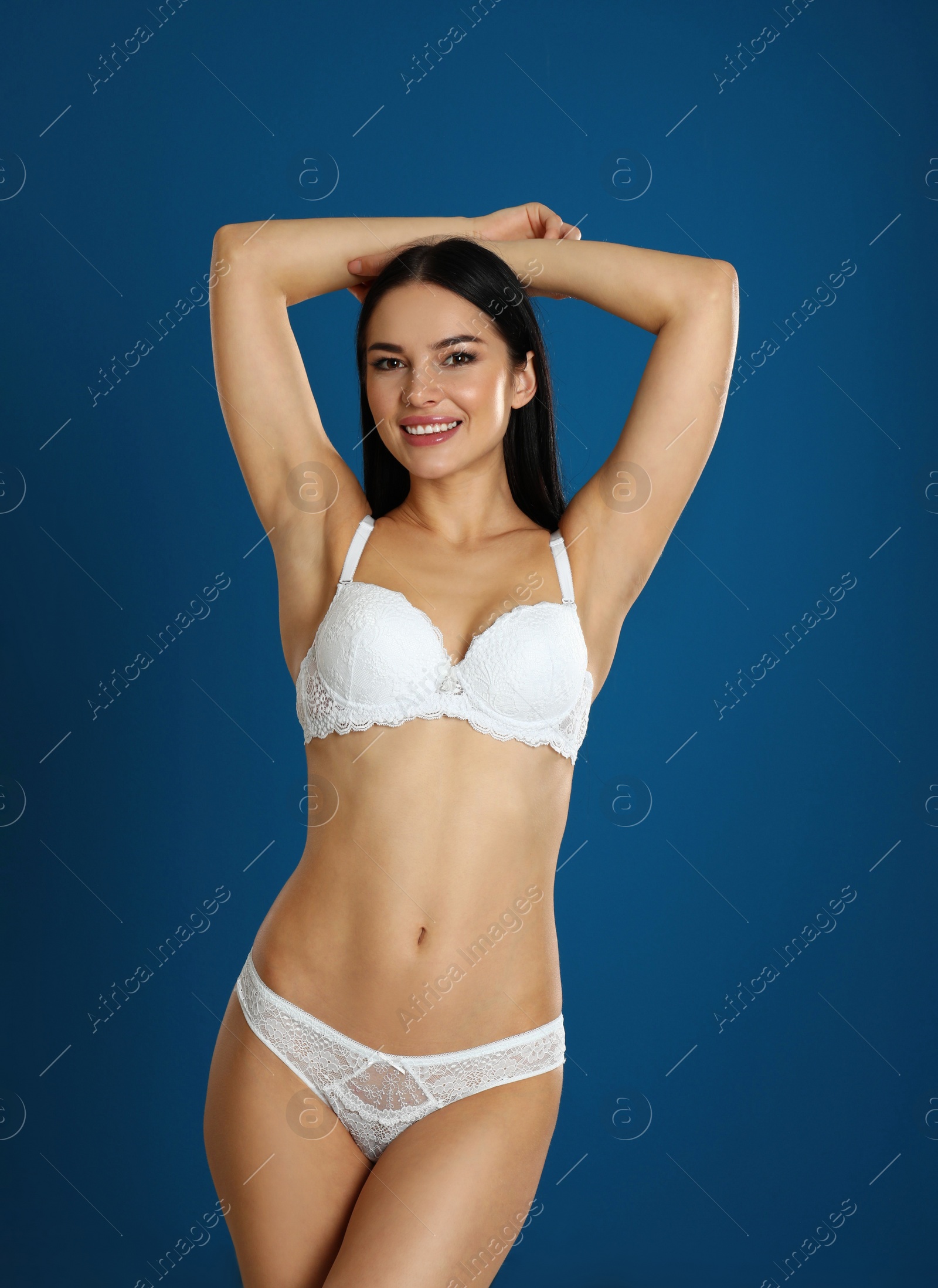 Photo of Beautiful young woman in white underwear on blue background