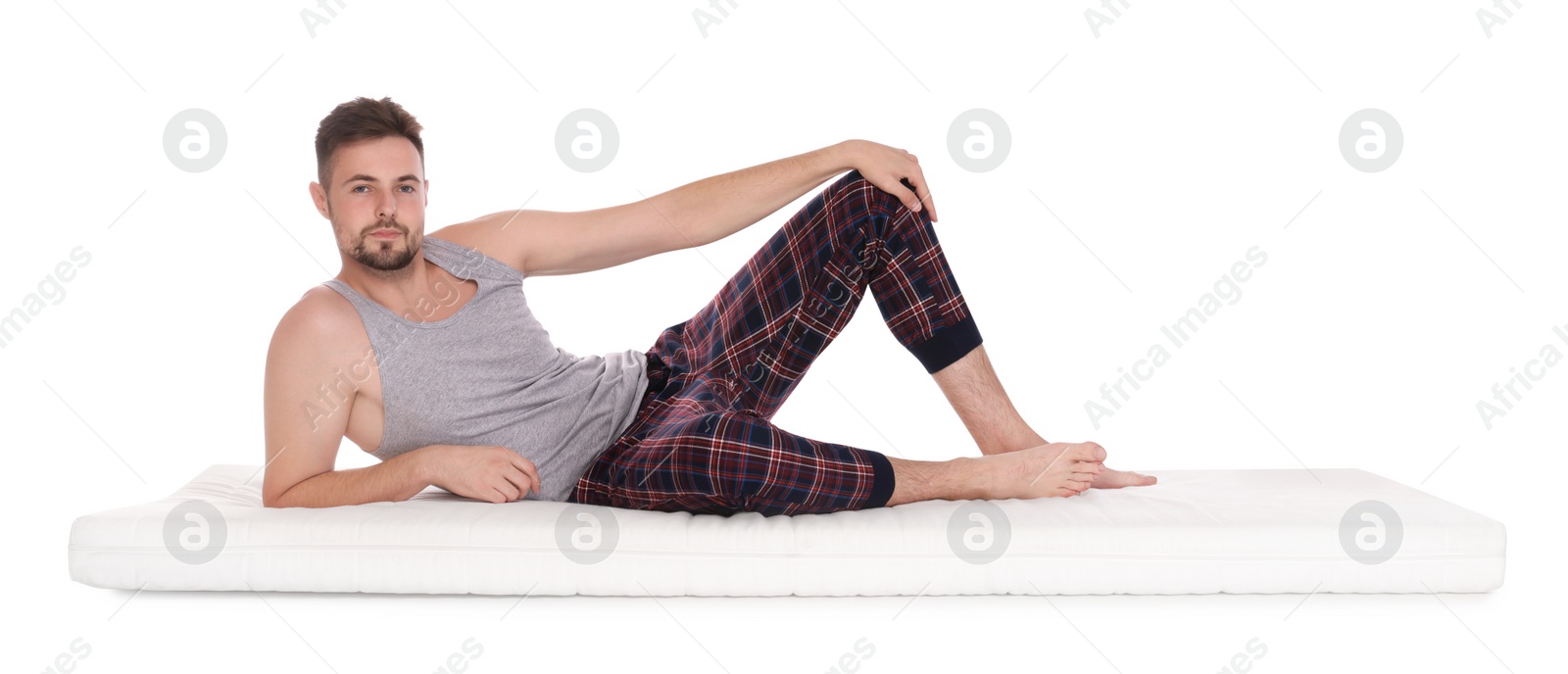 Photo of Man lying on soft mattress against white background