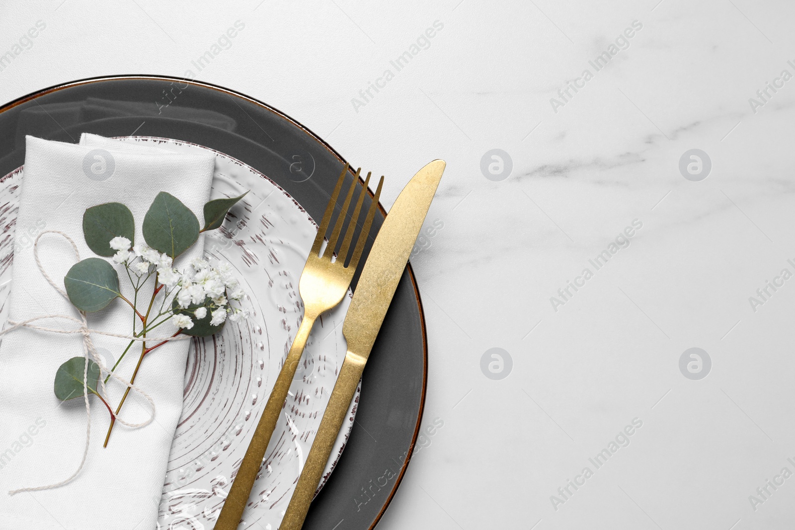 Photo of Stylish table setting with cutlery, flower and eucalyptus leaves, top view. Space for text