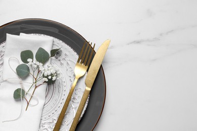 Photo of Stylish table setting with cutlery, flower and eucalyptus leaves, top view. Space for text