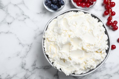 Tasty cream cheese and fresh berries on white marble table, flat lay. Space for text