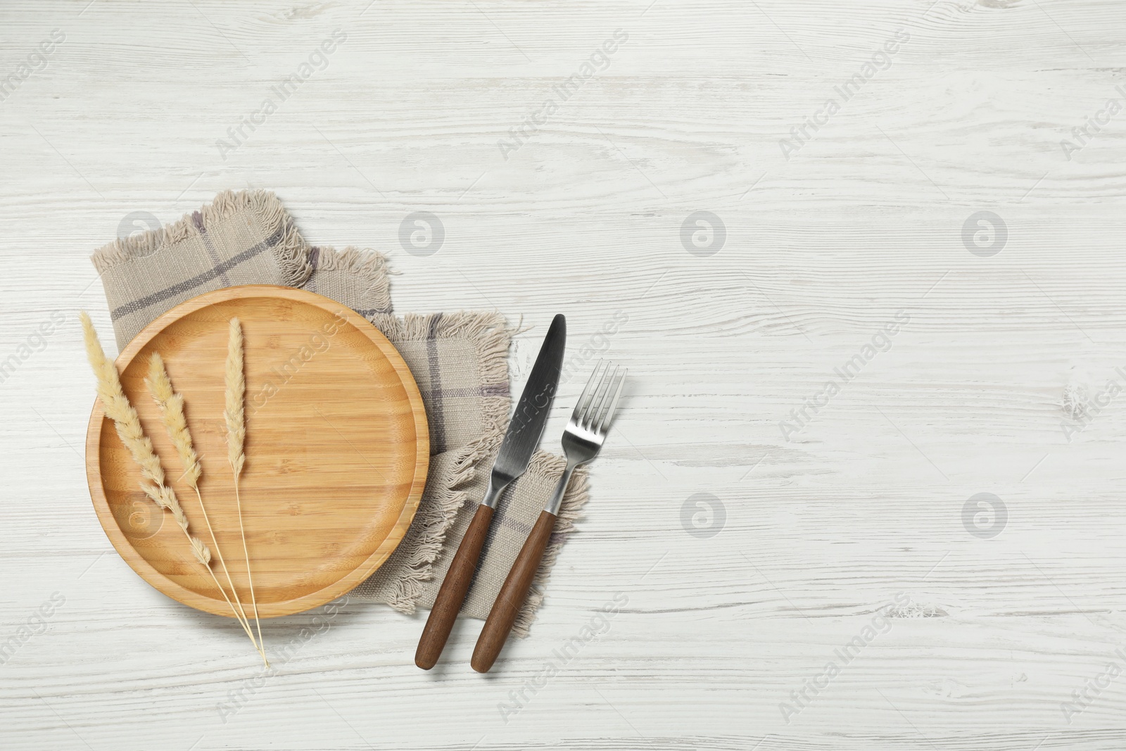 Photo of Stylish setting with elegant cutlery on white wooden table, top view. Space for text