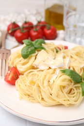 Photo of Delicious pasta with brie cheese, tomatoes and basil leaves on table, closeup