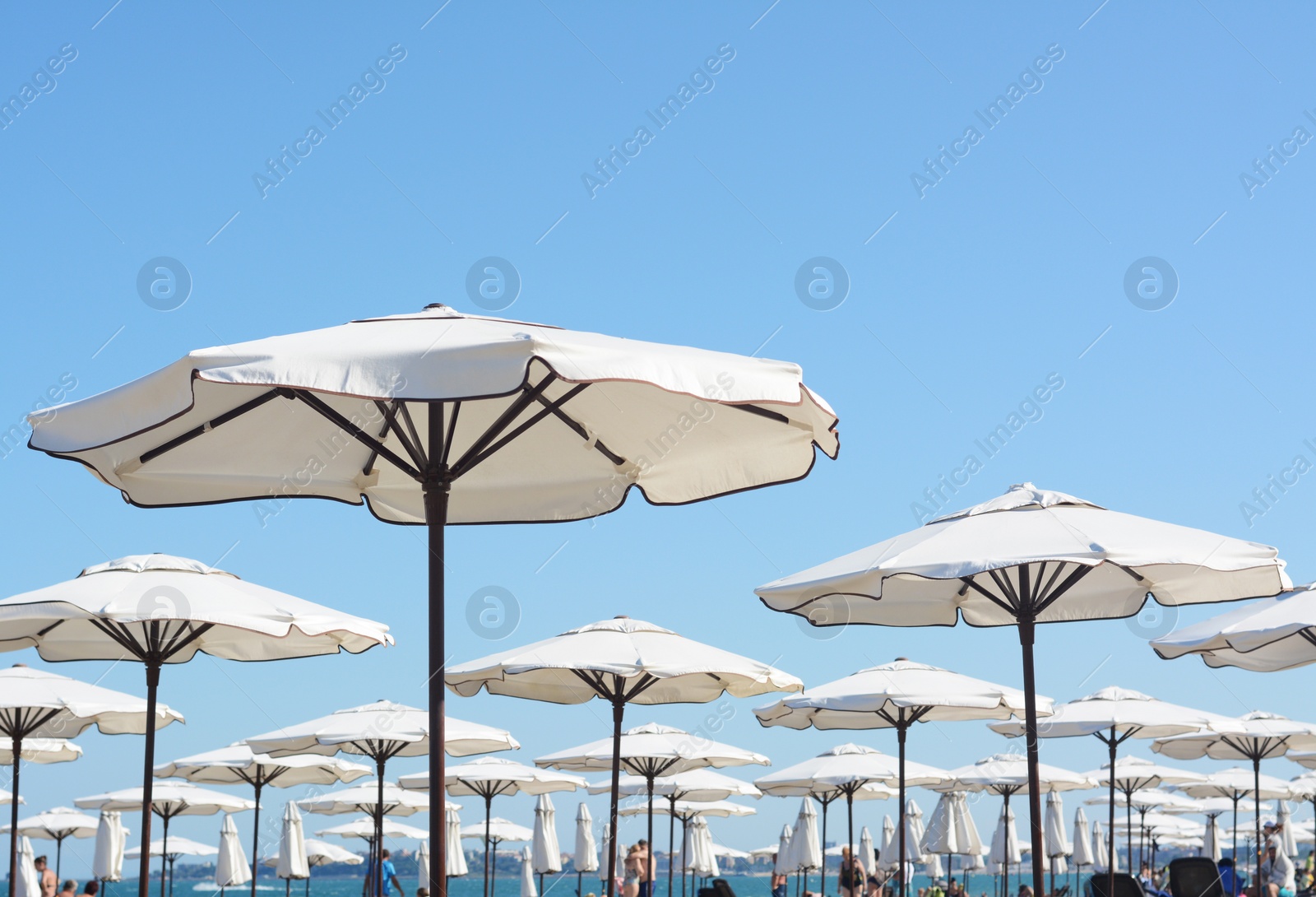 Photo of Beautiful white beach umbrellas against blue sky