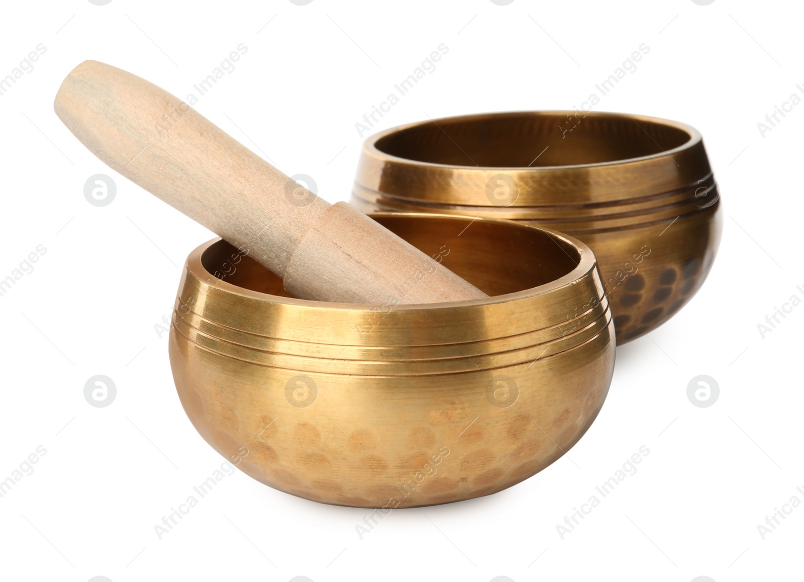 Photo of Golden singing bowls with mallet on white background. Sound healing