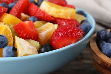 Photo of Delicious fresh fruit salad in bowl on table, closeup