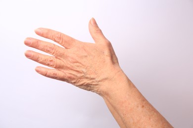 Photo of Closeup view of older woman's hand on white background