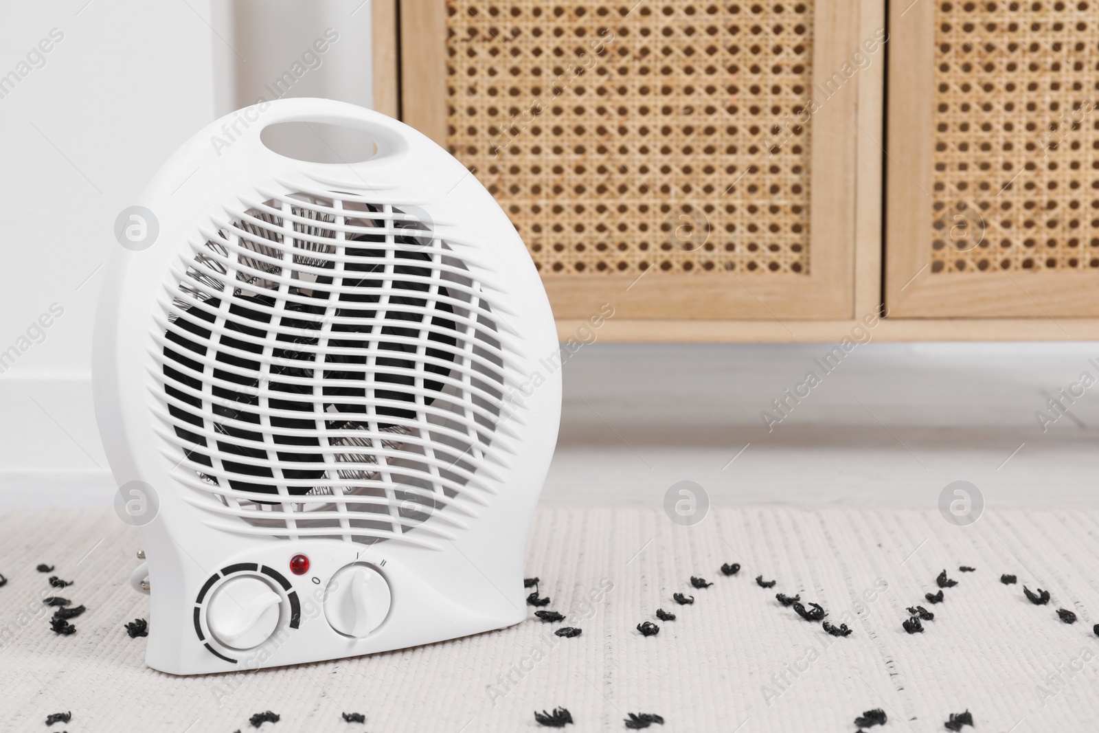 Photo of Electric fan heater on floor at home. Space for text
