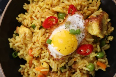Photo of Tasty rice with meat, egg and vegetables in bowl, top view