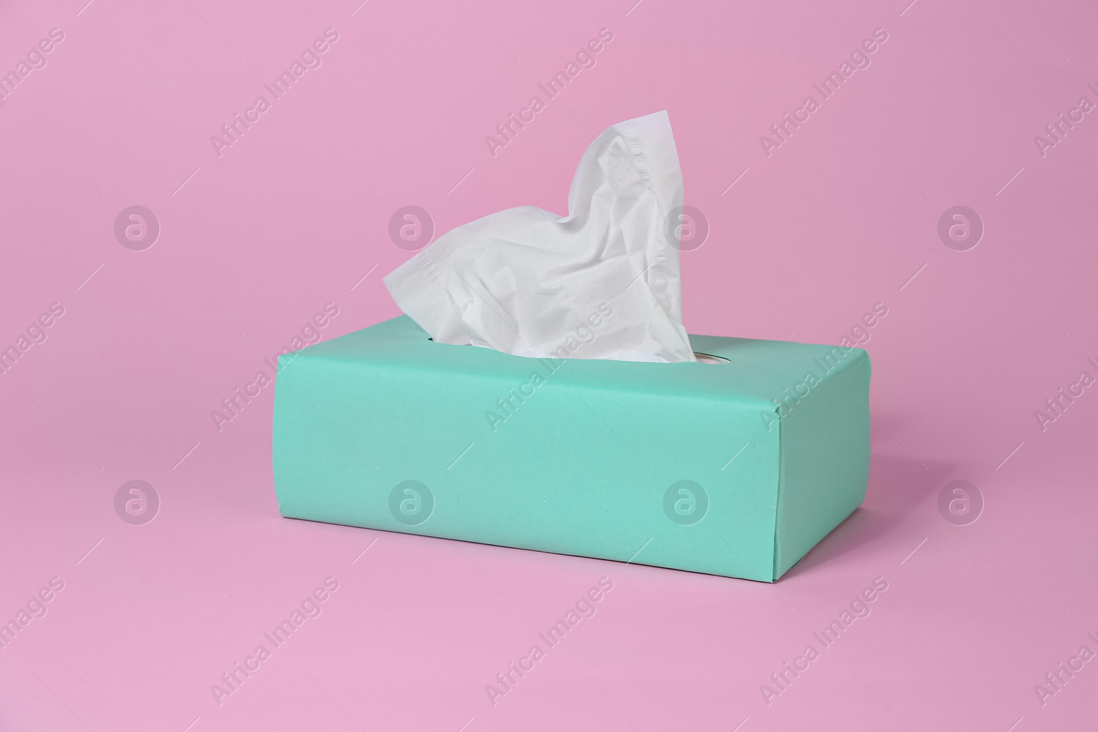 Photo of Box with paper tissues on pink background