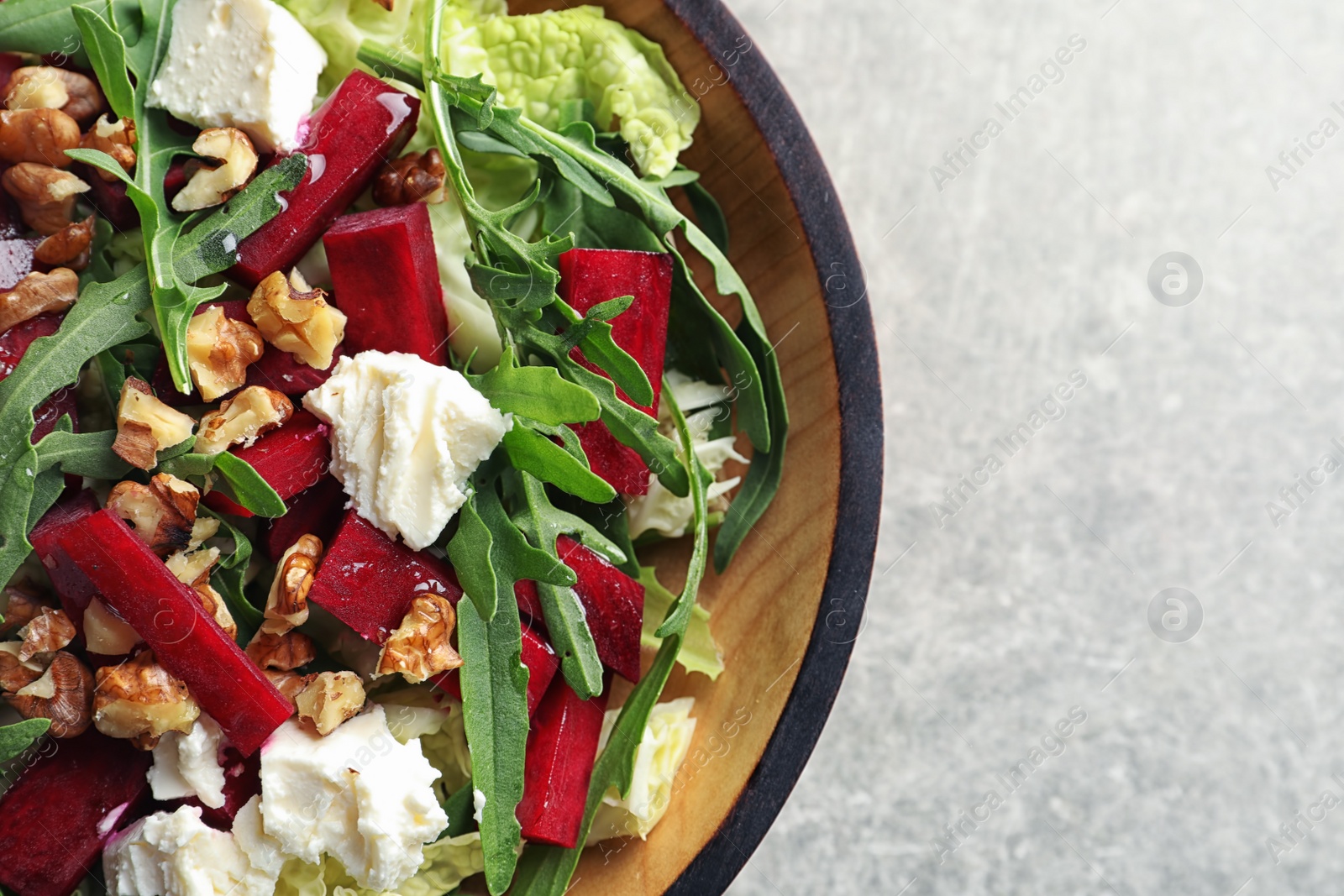 Photo of Bowl with tasty beets salad on table, closeup