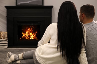 Photo of Lovely couple spending time together near fireplace at home