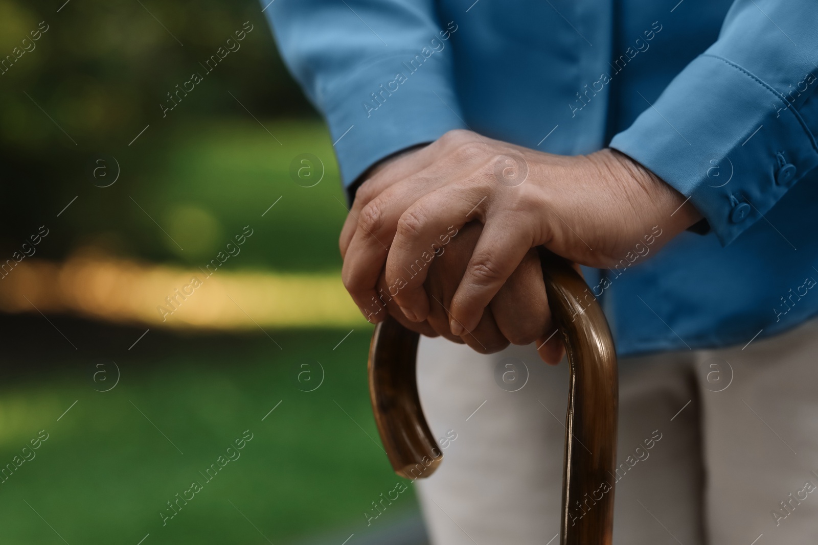 Photo of Senior woman with walking cane outdoors, closeup. Space for text