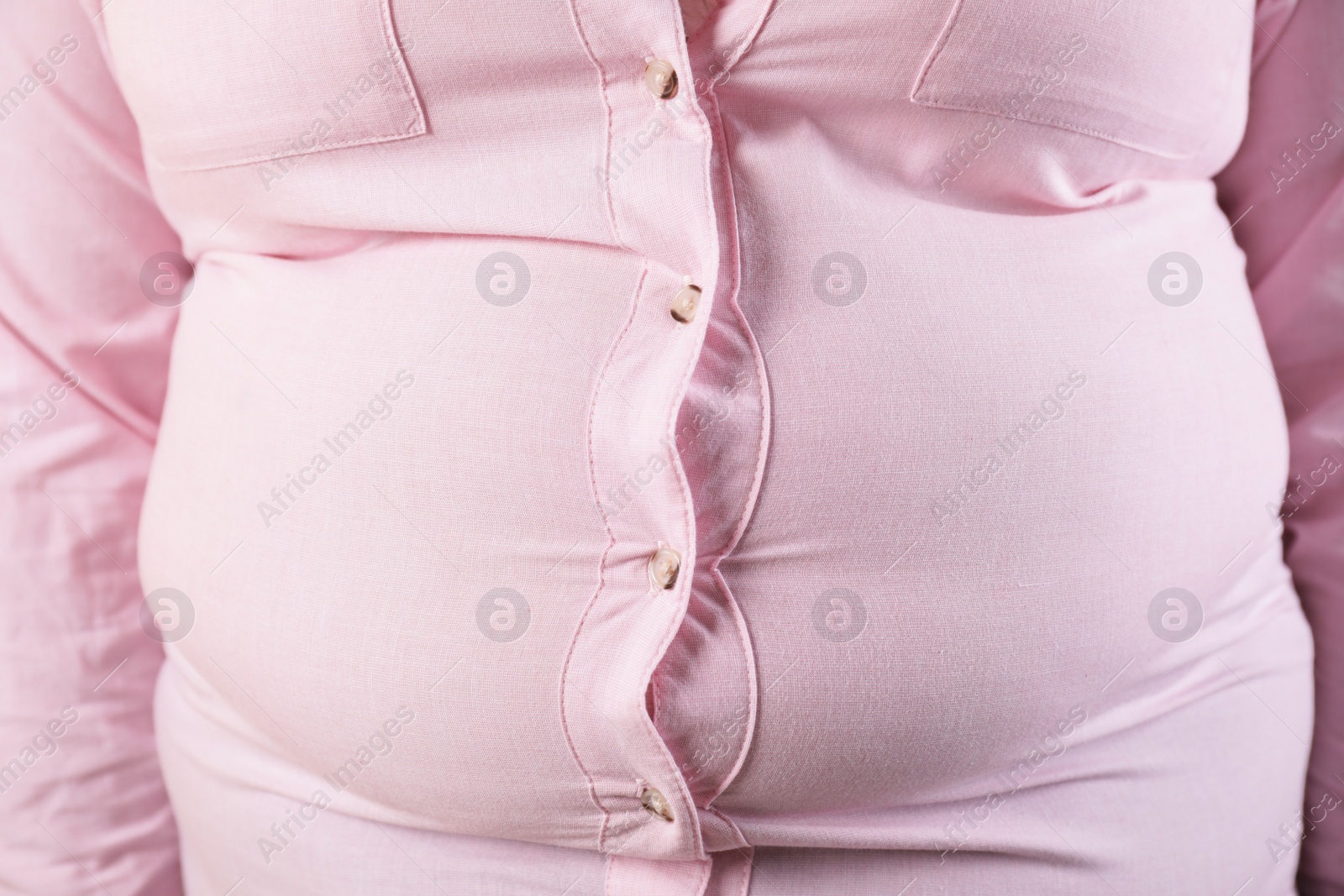 Photo of Overweight woman in tight shirt, closeup. Obesity and weight loss