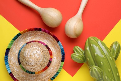 Maracas, toy cactus and sombrero hat on colorful background, flat lay. Musical instrument