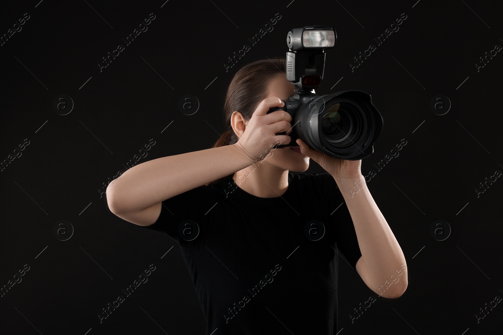 Photo of Professional photographer taking picture on black background