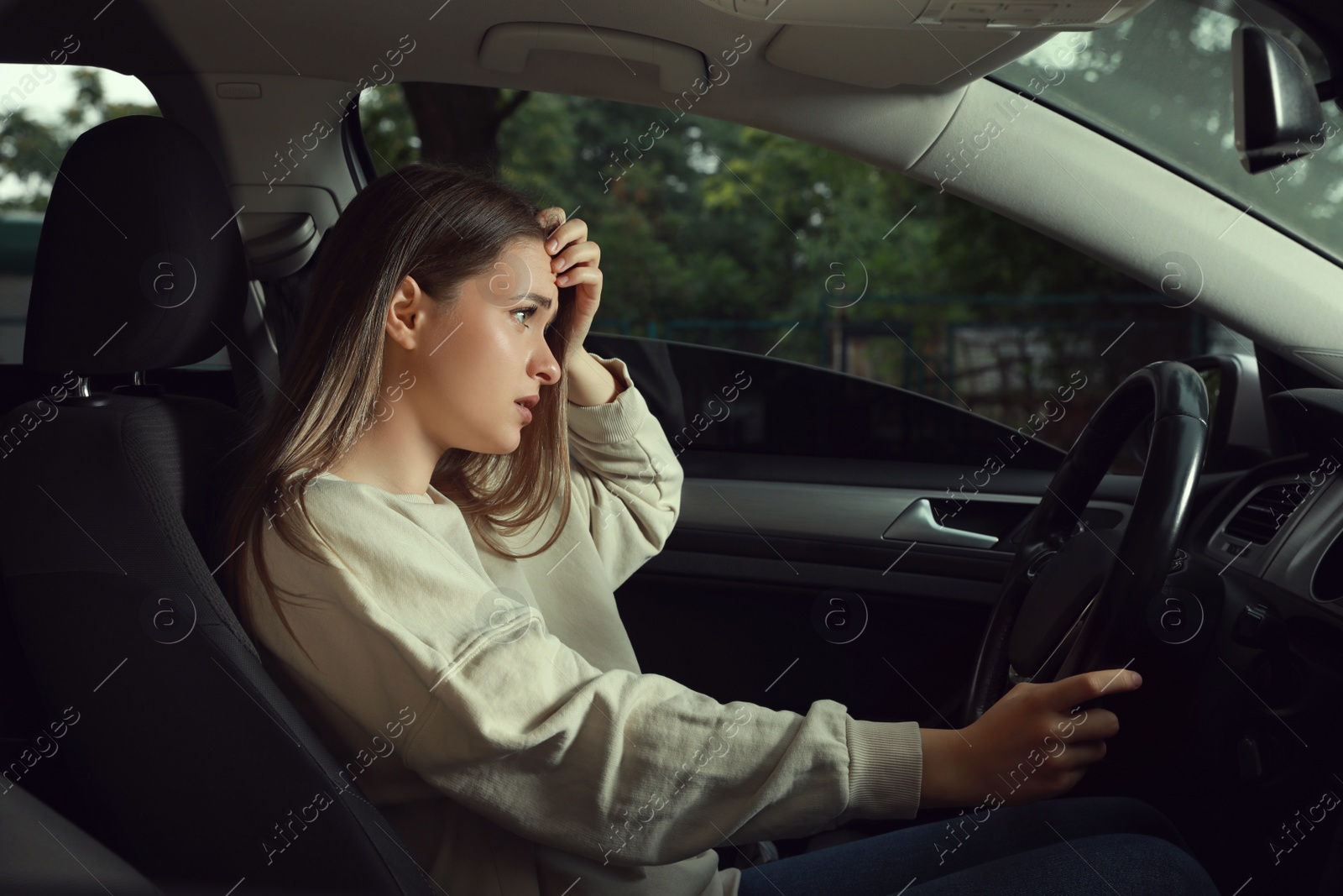 Photo of Stressed young woman in driver's seat of modern car