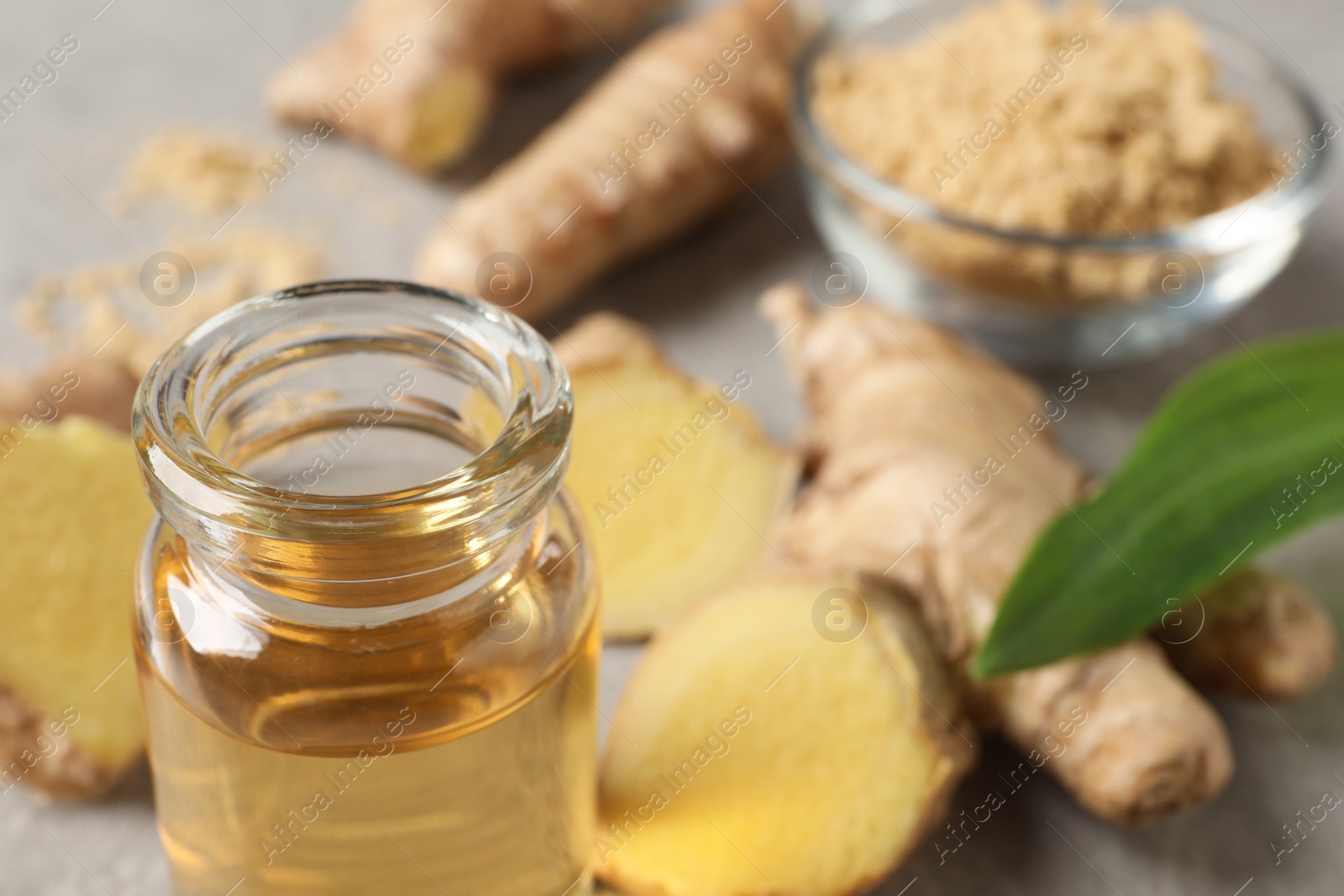 Photo of Glass bottle of ginger essential oil on table, closeup. Space for text