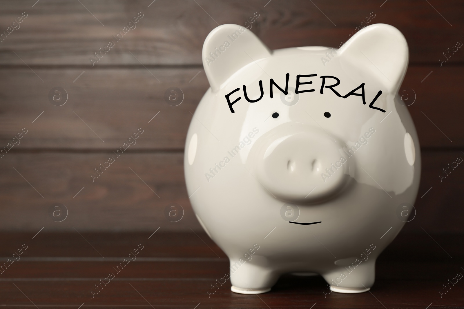 Image of Money for funeral expenses. White piggy bank on wooden table. Space for text