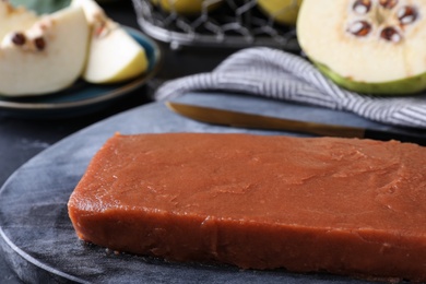 Photo of Delicious quince paste on board, closeup view
