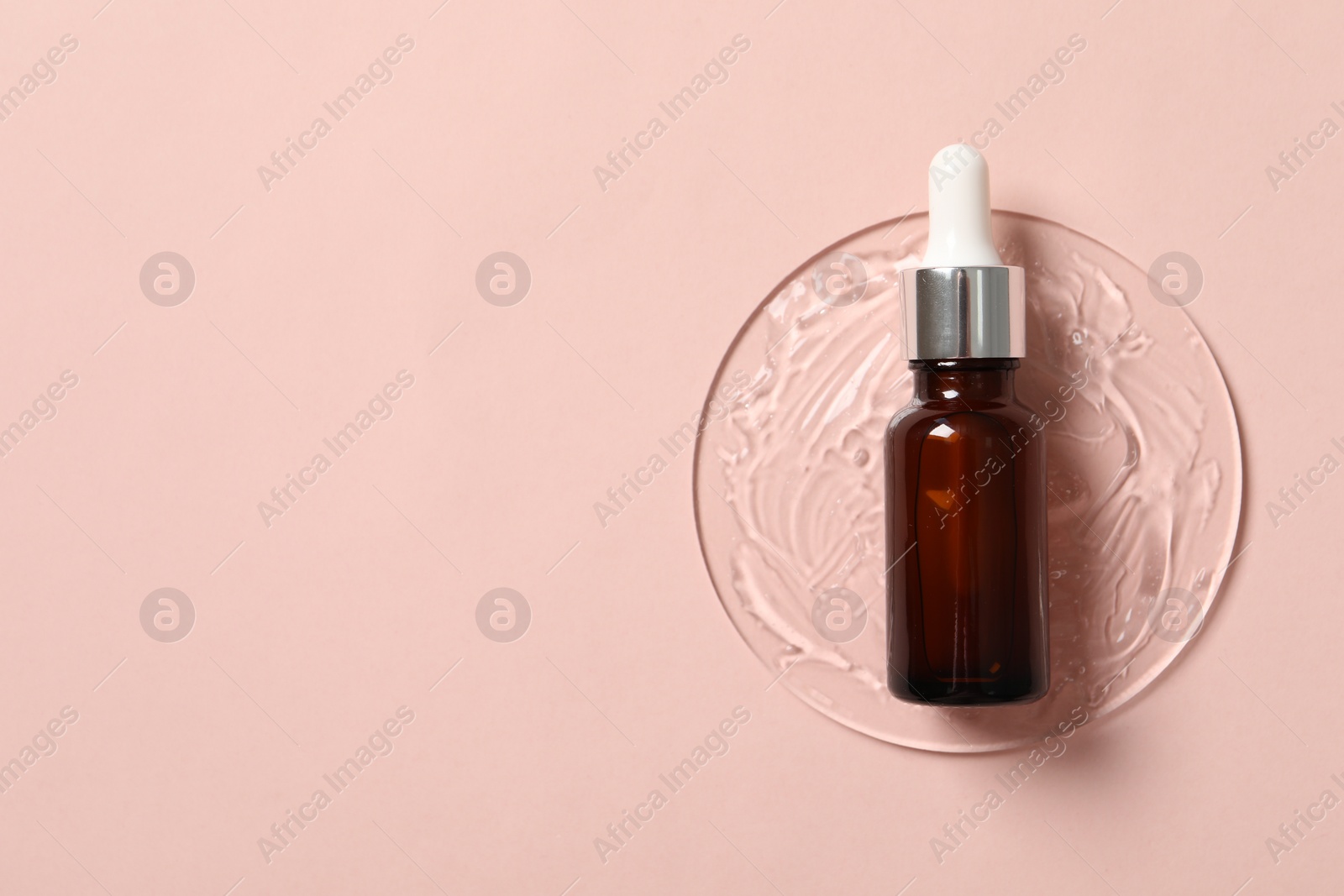 Photo of Bottle of cosmetic serum on pink background, top view. Space for text