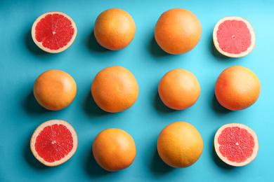 Photo of Cut and whole ripe grapefruits on blue background, flat lay