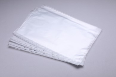 Punched pockets on light grey background. Document protection